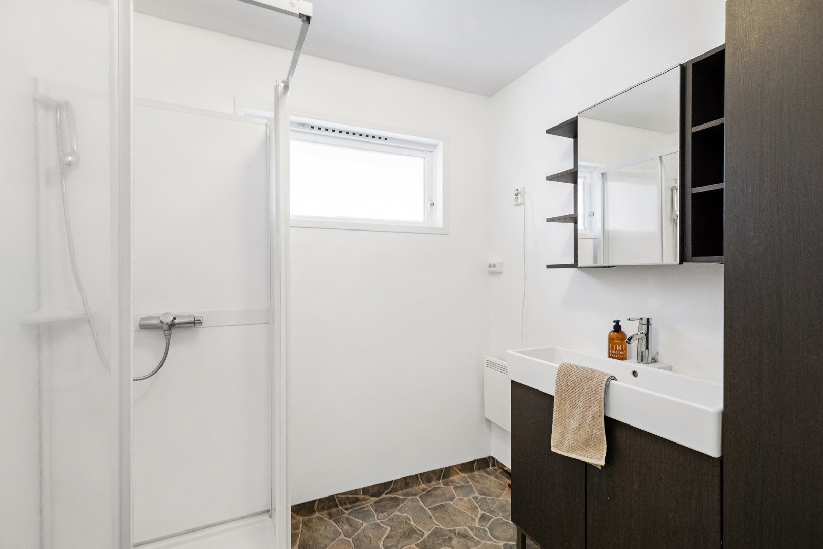 Badet har vinylbelegg på gulv med malte overflater på vegger og i tak. Det er innredet med nedfelt servant, toalett og dusjkabinett. Galleribilde