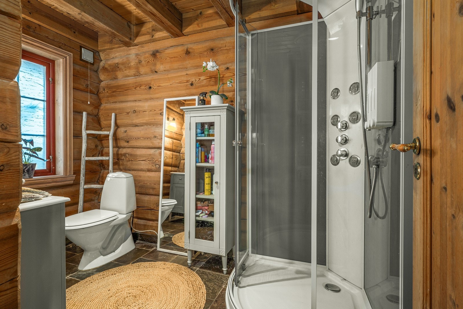 Bad innredet med servant på underskap, klosett og dusjkabinett. Galleribilde