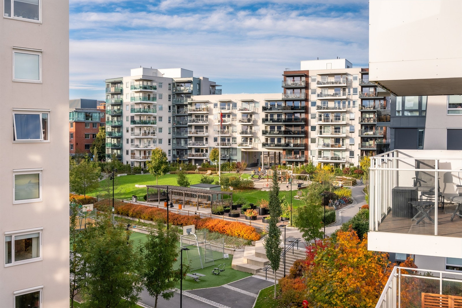 Bilde på sommerstid av bakgården. Bilde er hentet fra en annen balkong enn denne leiligheten. Galleribilde