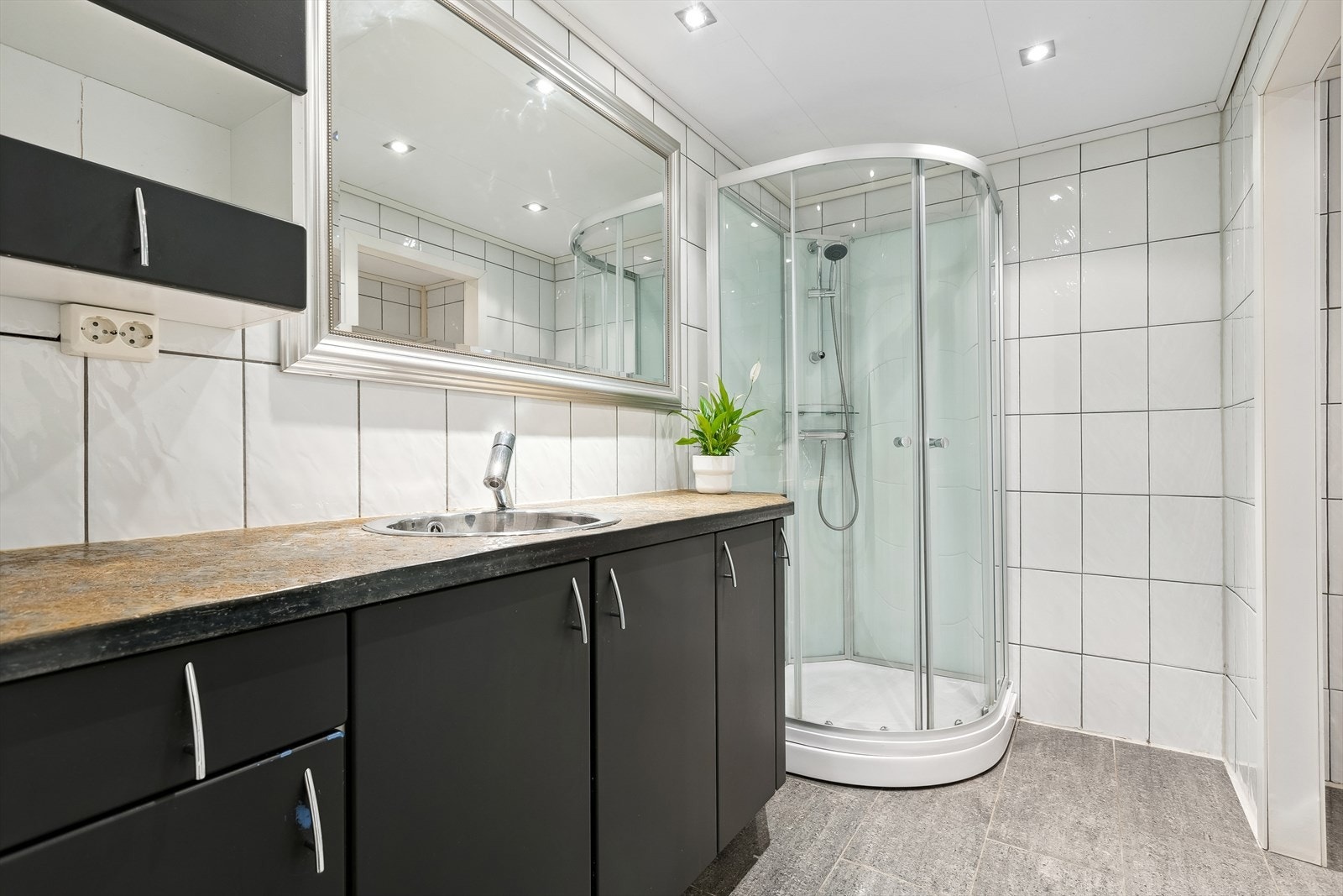 Flislagt bad på 6m² utstyrt med behagelig gluvvarme, naturlig avtrekk, servantskap og dusjkabinett Galleribilde