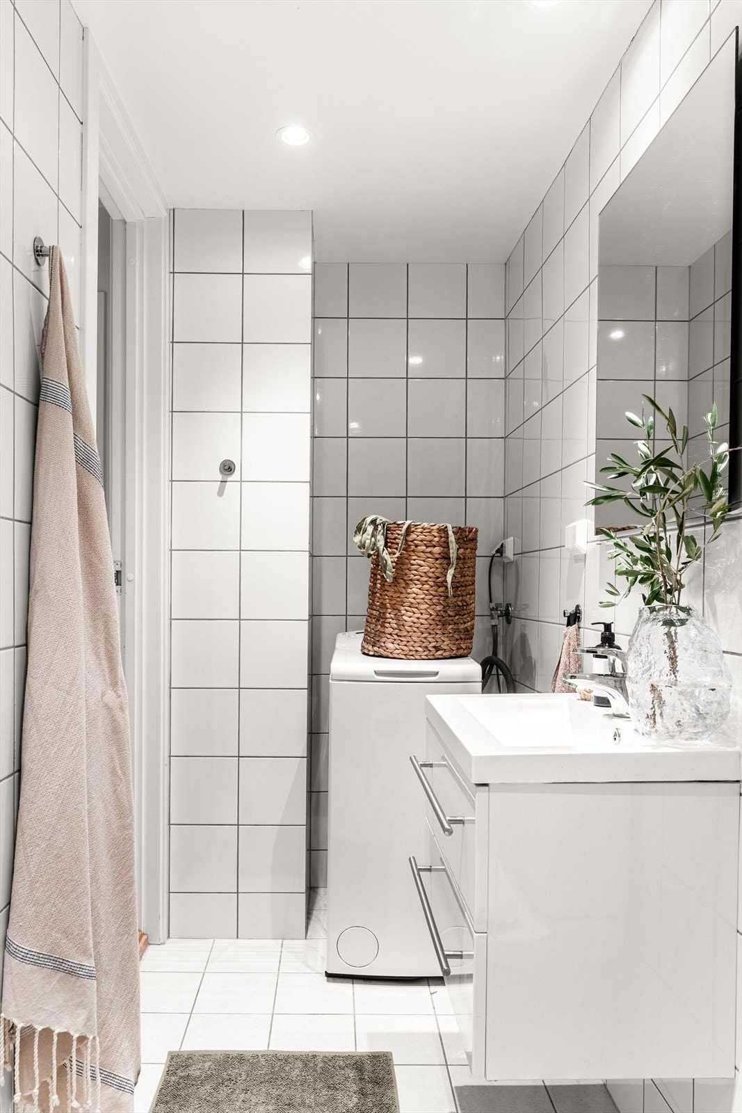 Badet er innredet med heldekkende servant m/ bl.batteri og speil + lys, frittstående toalett og åpen dusjplass med forheng. Opplegg for smal vaskemaskin. Naturlig ventilasjon fra badet via kanal til sjakt/pipeløp på kjøkkenet. Galleribilde