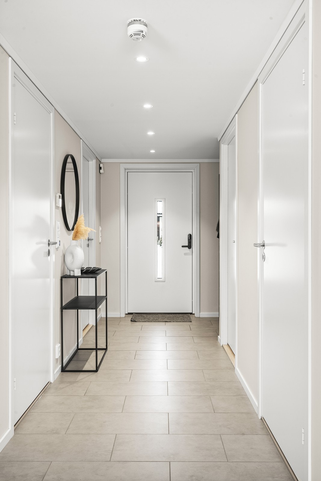Velkommen inn i en lys entré med slitesterke gulvfliser og downlights i taket. Galleribilde