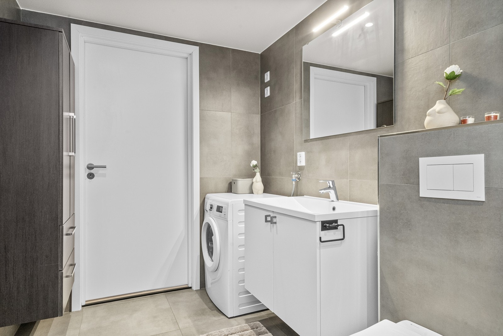 Baderomsinnredning med servant og et høyskap gir god oppbevaringsplass. Galleribilde