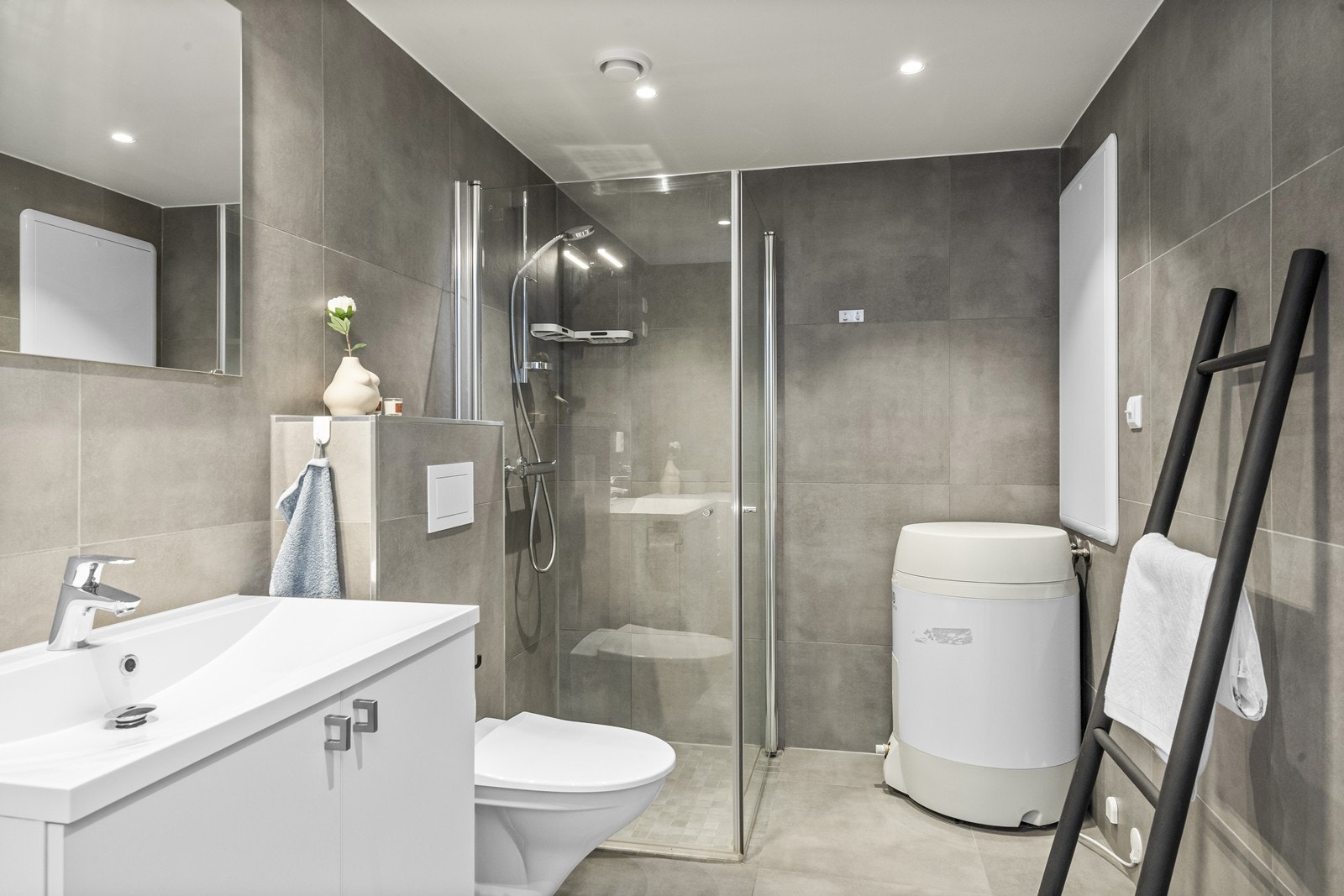 Badet er helfliset med moderne, store fliser på gulv og vegger. Galleribilde