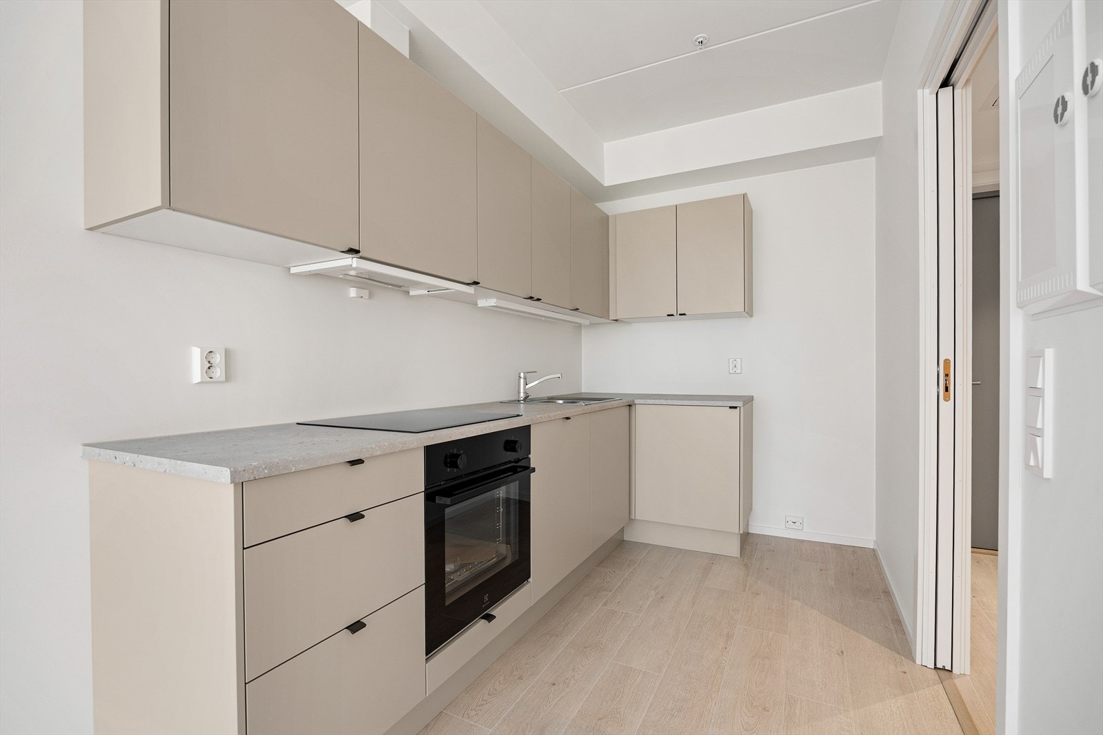 Kjøkkeninnredningen har slette, lyse fronter og en slitesterk laminatbenkeplate. Galleribilde