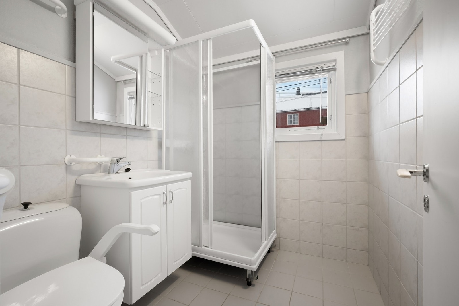 Eldre baderom med dusjkabinett, servantinnredning og toalett Galleribilde