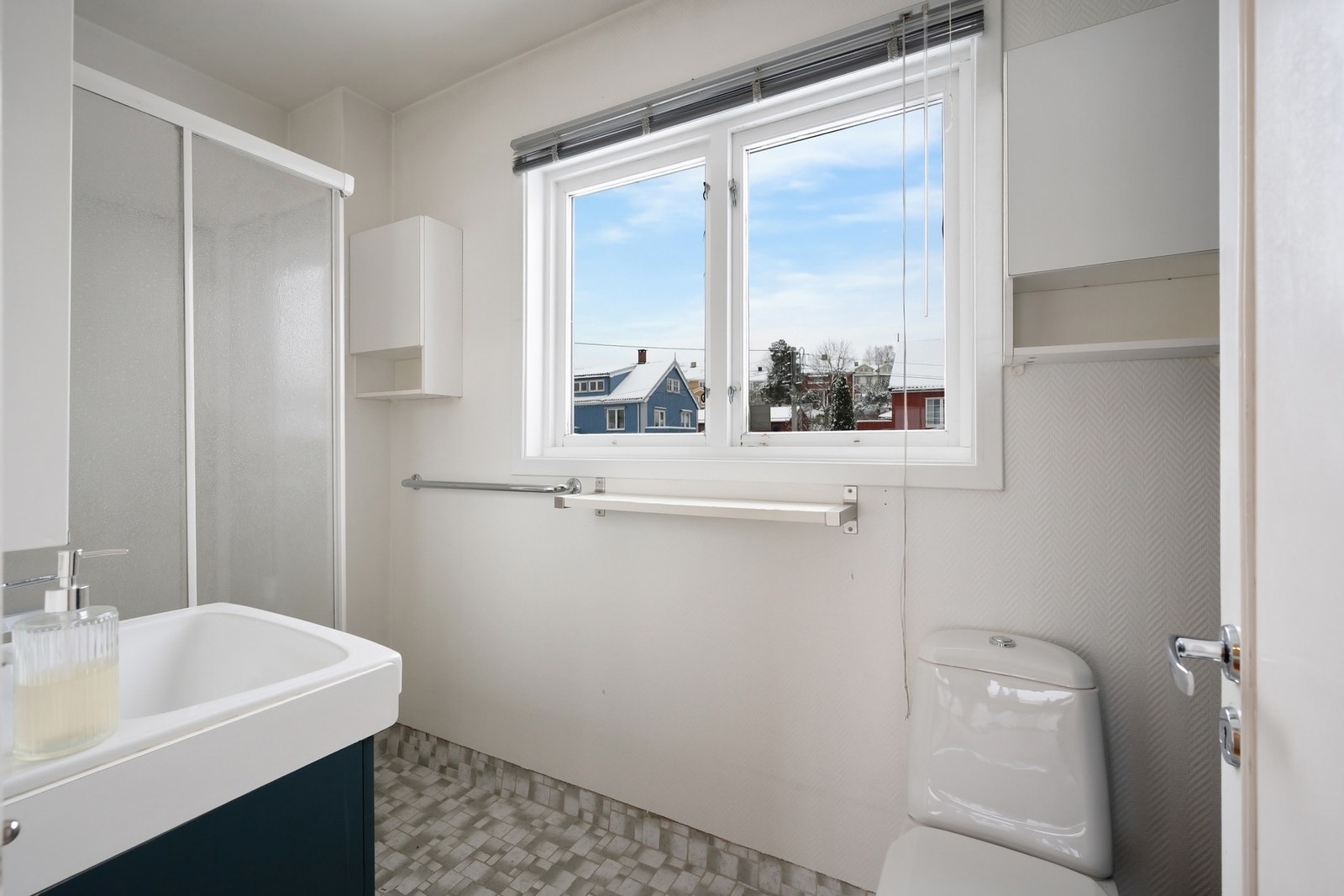 Eldre baderom med flislagt gulv, dusjkabinett, servant og toalett Galleribilde