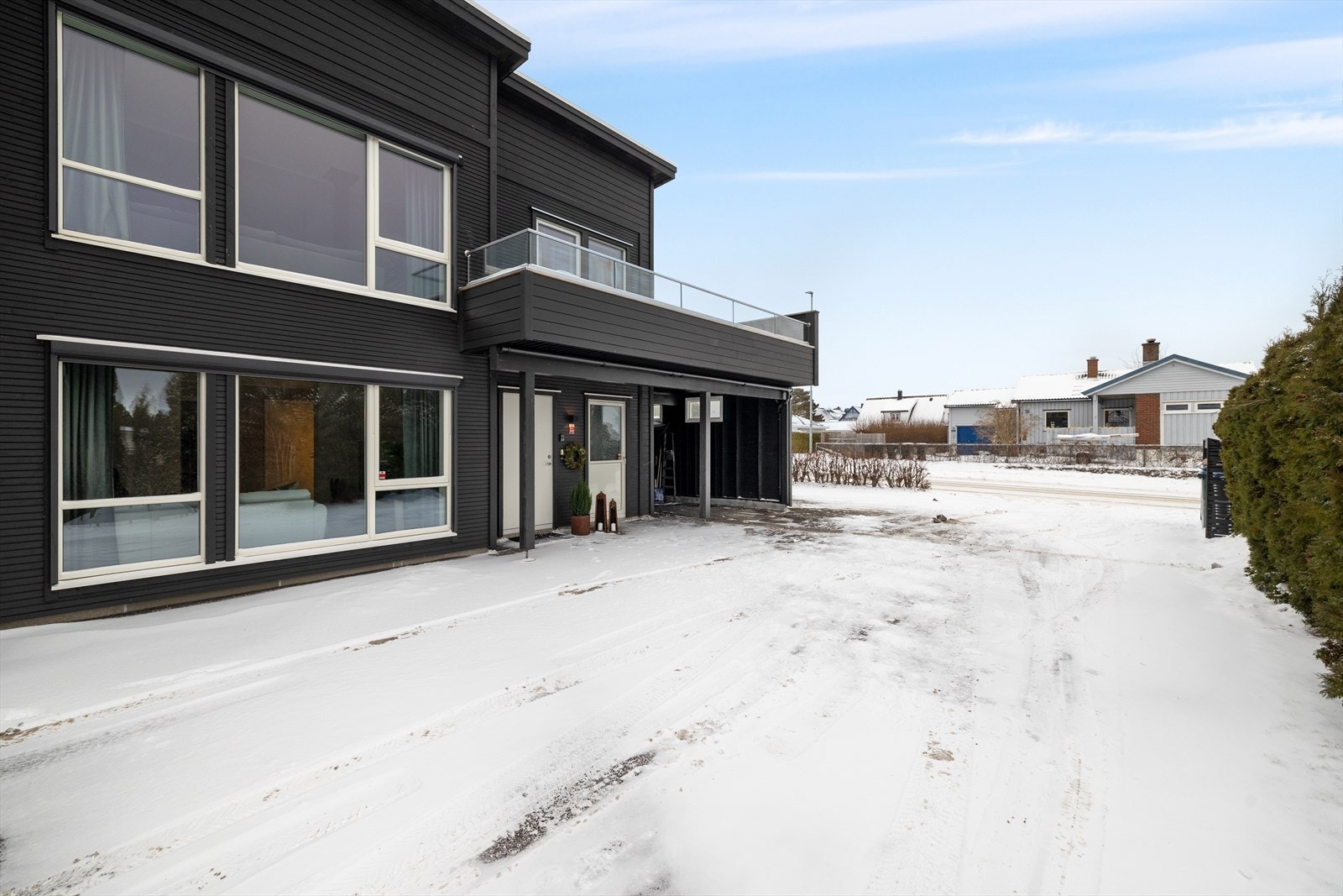 Ved inngangspartiet er det en romslig gårdsplass som leder inn til den praktiske carporten med tilhørende bod. Galleribilde