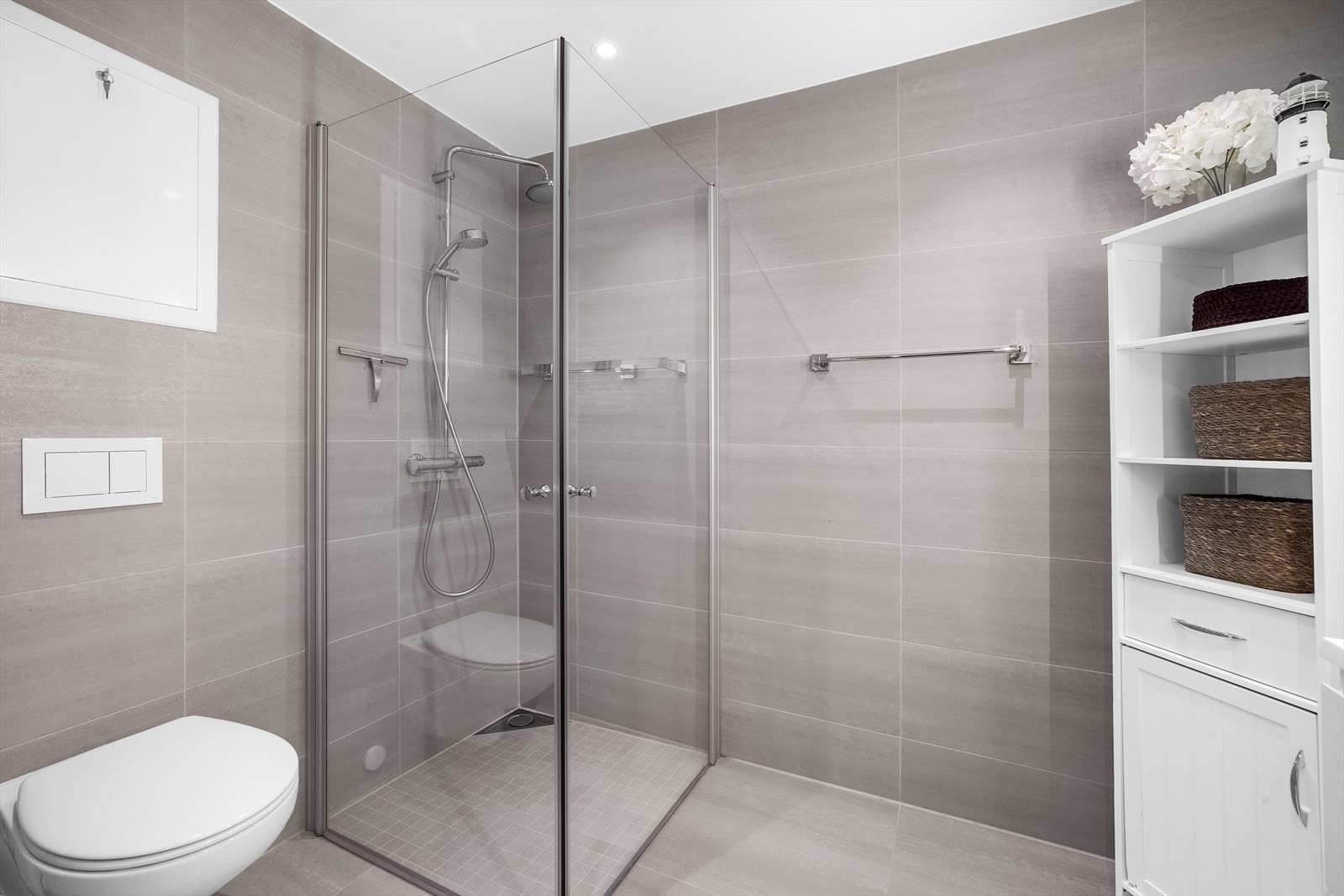 Baderommet har moderne fliser både på gulv og vegger, mot slett himling med downlights. Galleribilde