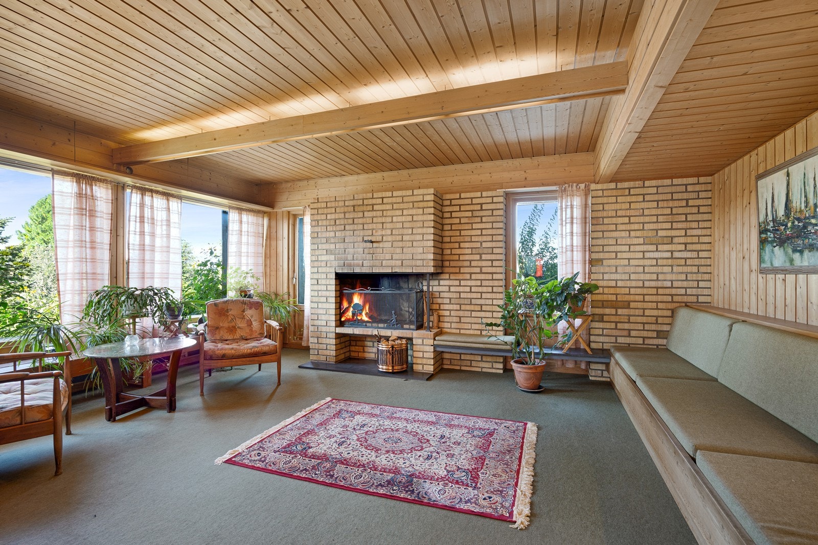 Stuen er i en minimalistisk stil i harmoni med byggetiden for boligen. Rommet har en stor, åpen peis hvor åpne flammer kan nytes fullt ut. Galleribilde