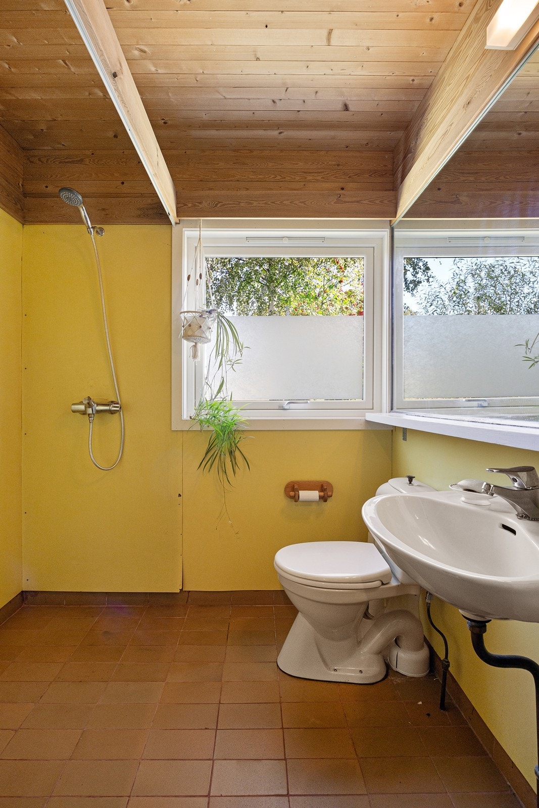 Badet som ligger vegg-i-vegg med grovinngang har flislagt gulv og ellers en enkel standard. Galleribilde