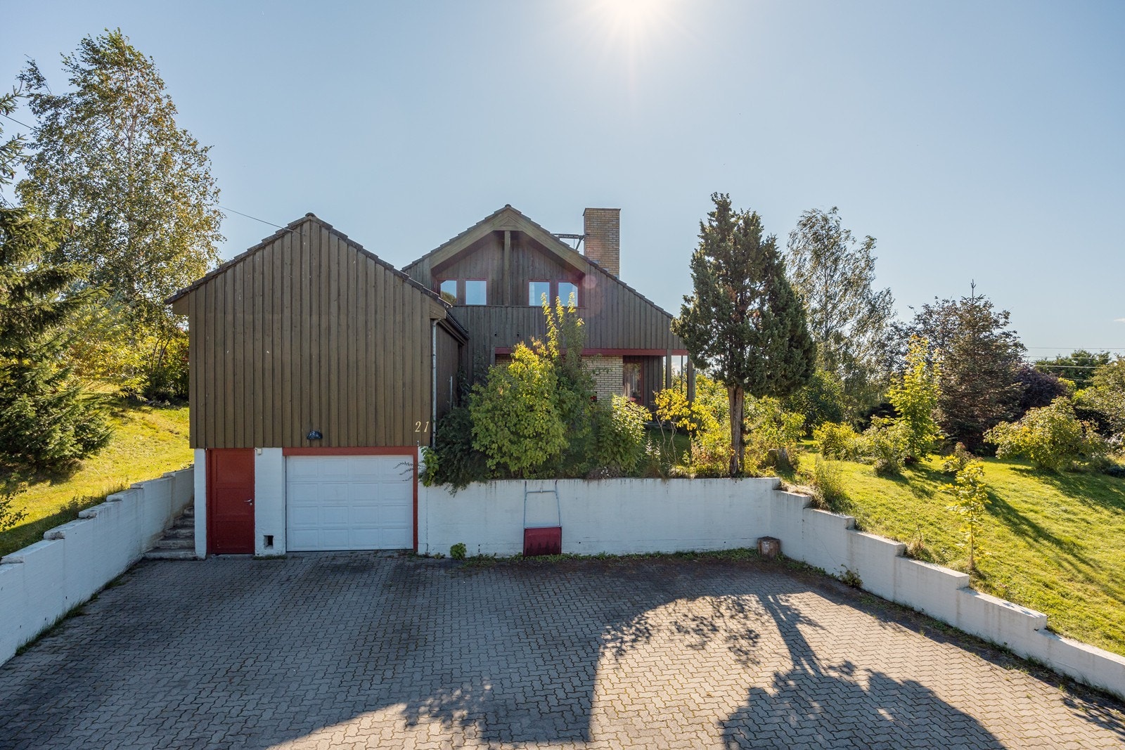 Det er parkering i integrert garasje med motorisert leddport og elektrisk åpner. I tillegg er det god plass til flere biler på steinlagt gårdsplass. Galleribilde