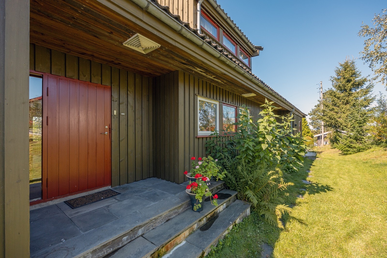 Hovedinngangen er overbygget med tak og en romslig inngangsdør. Galleribilde