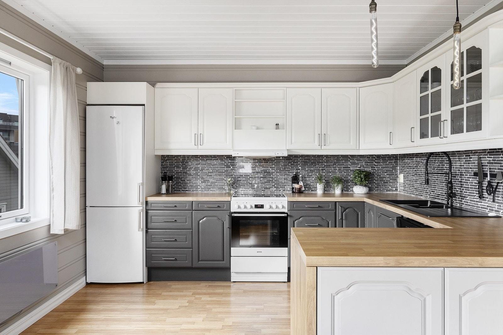 Klassisk kjøkkeninnredning med profilerte fronter og benkeplate av laminat. Galleribilde