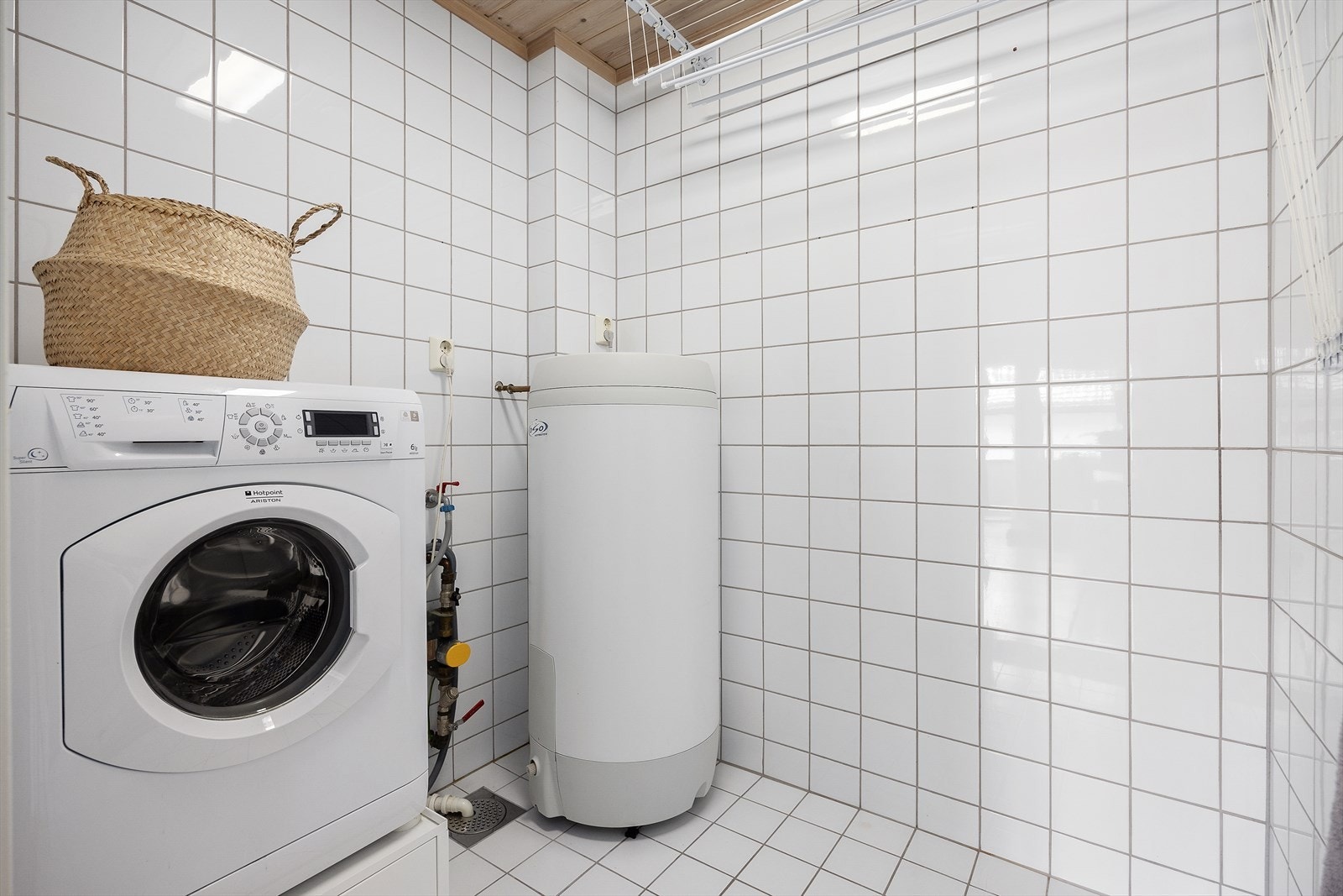 Praktisk flislagt vaskerom med opplegg for vaskemaskin. Galleribilde