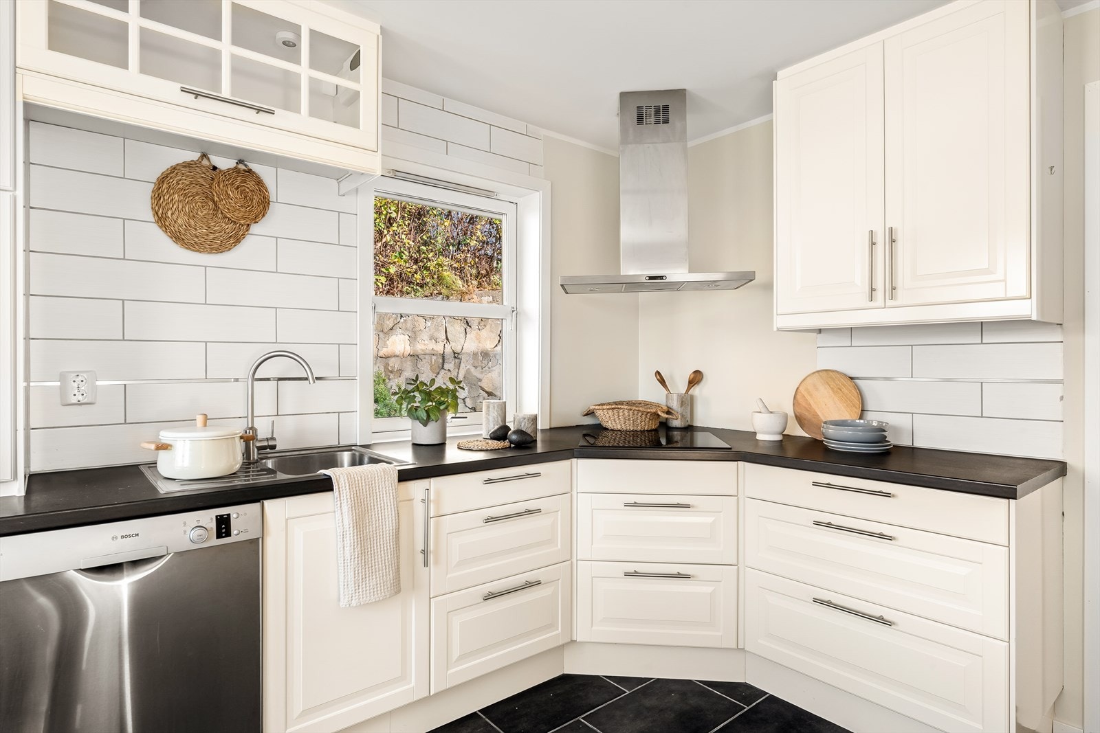 Et stilrent og klassisk kjøkken som imponerer med sine hvite profilerte fronter og en mørk granitt benkeplate. Galleribilde