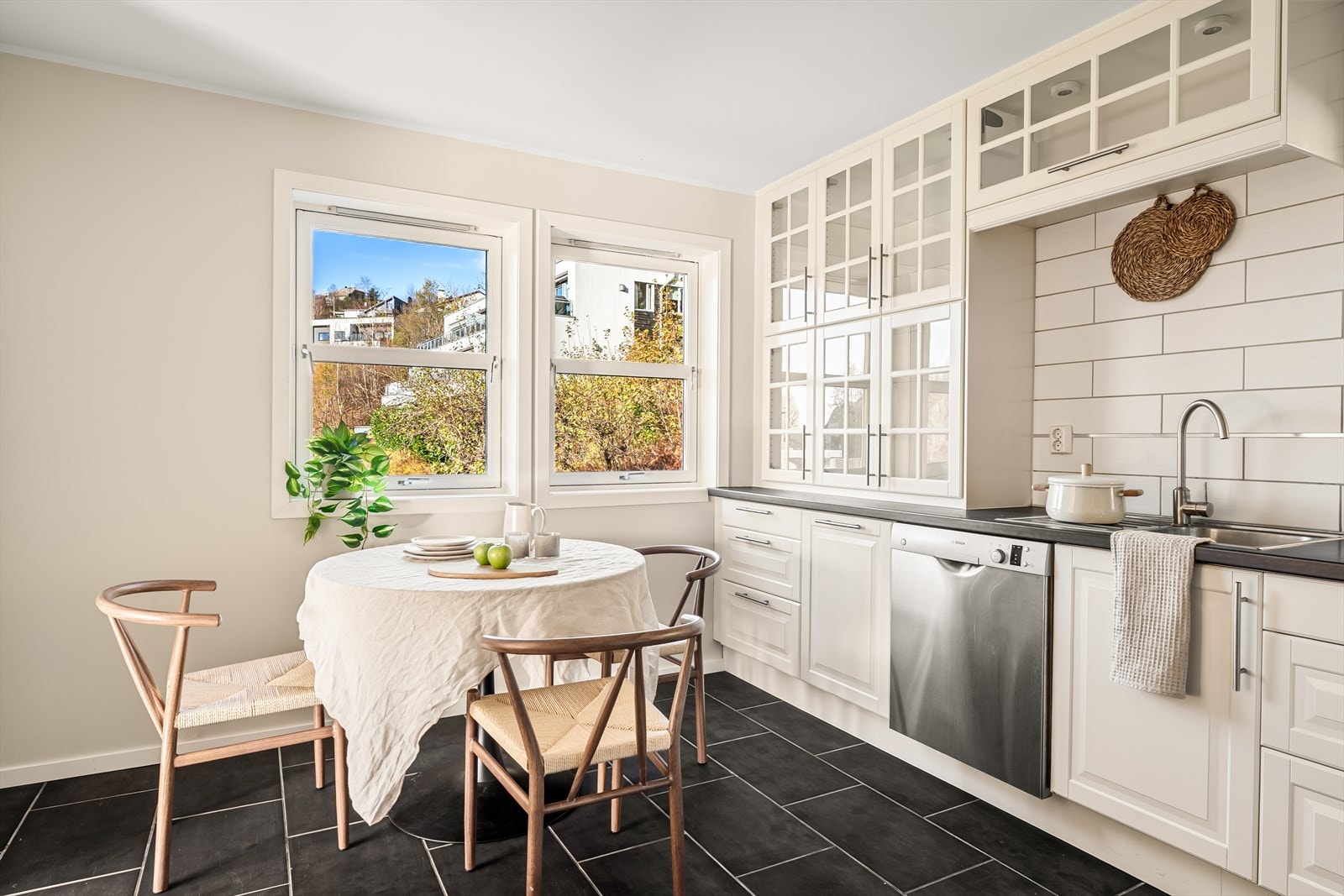 Lys og innbydende kjøkkenkrok med store vinduer som slipper inn naturlig lys, perfekt for hyggelige måltider og samvær. Galleribilde