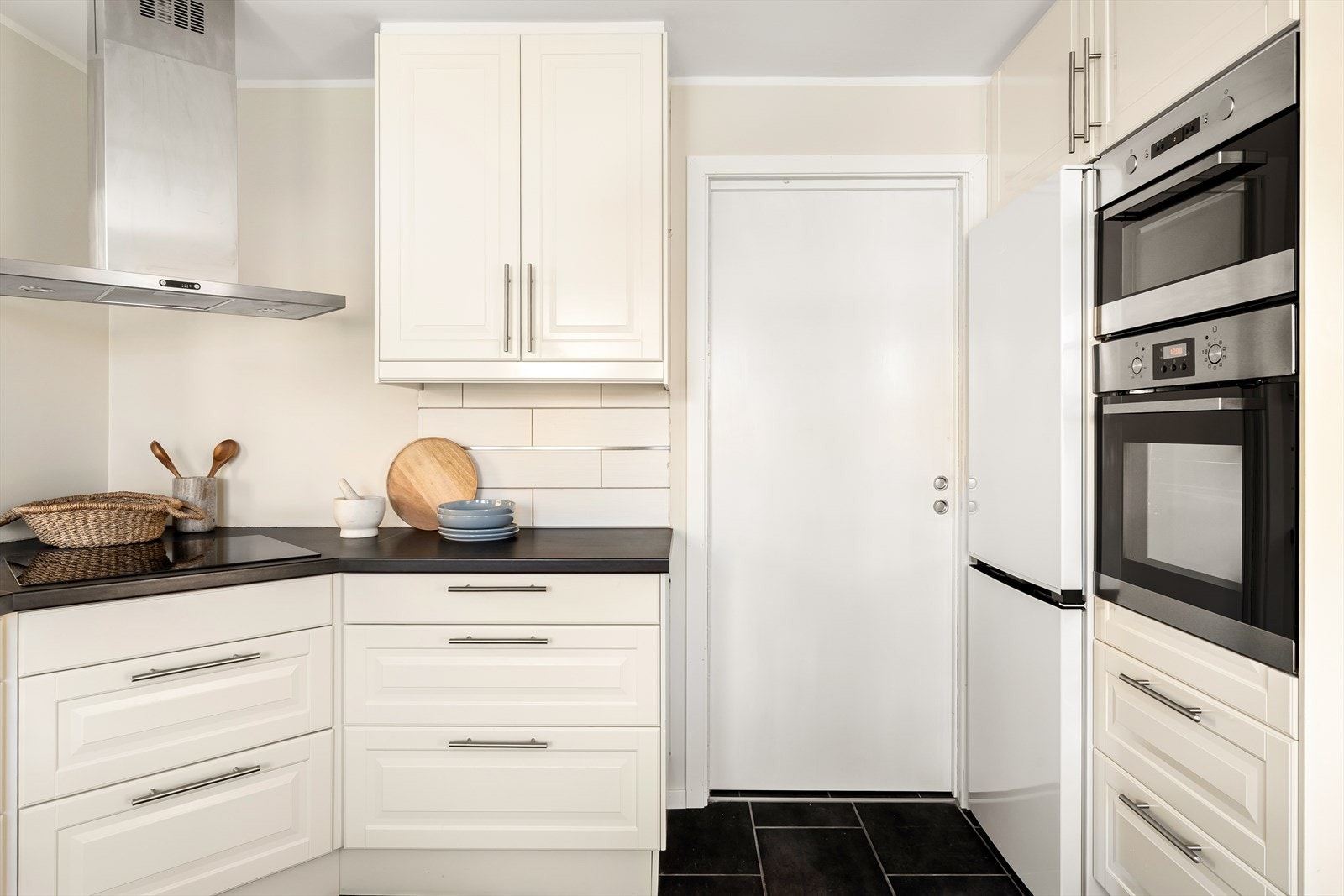 De integrerte hvitevarene og sorte flisene på gulvet med varmekabler skaper et eksklusivt preg. Galleribilde