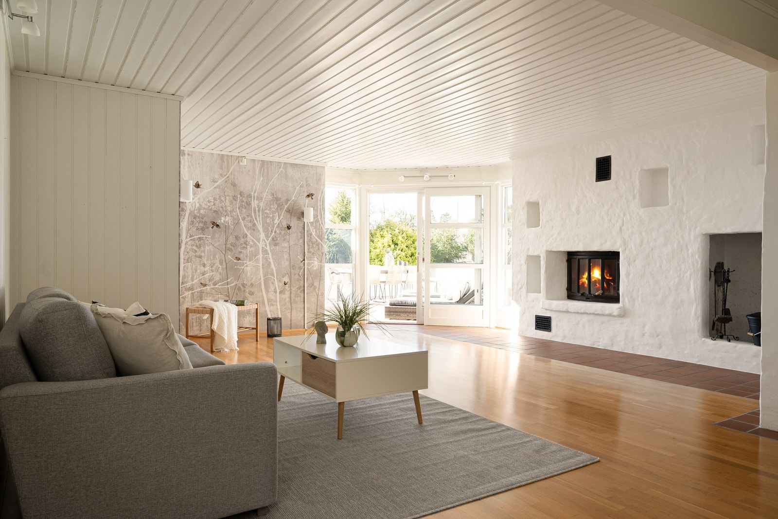 I den romslige kjellerstuen er det både stemningsskapende peis og varmekabler i gulvet. Galleribilde