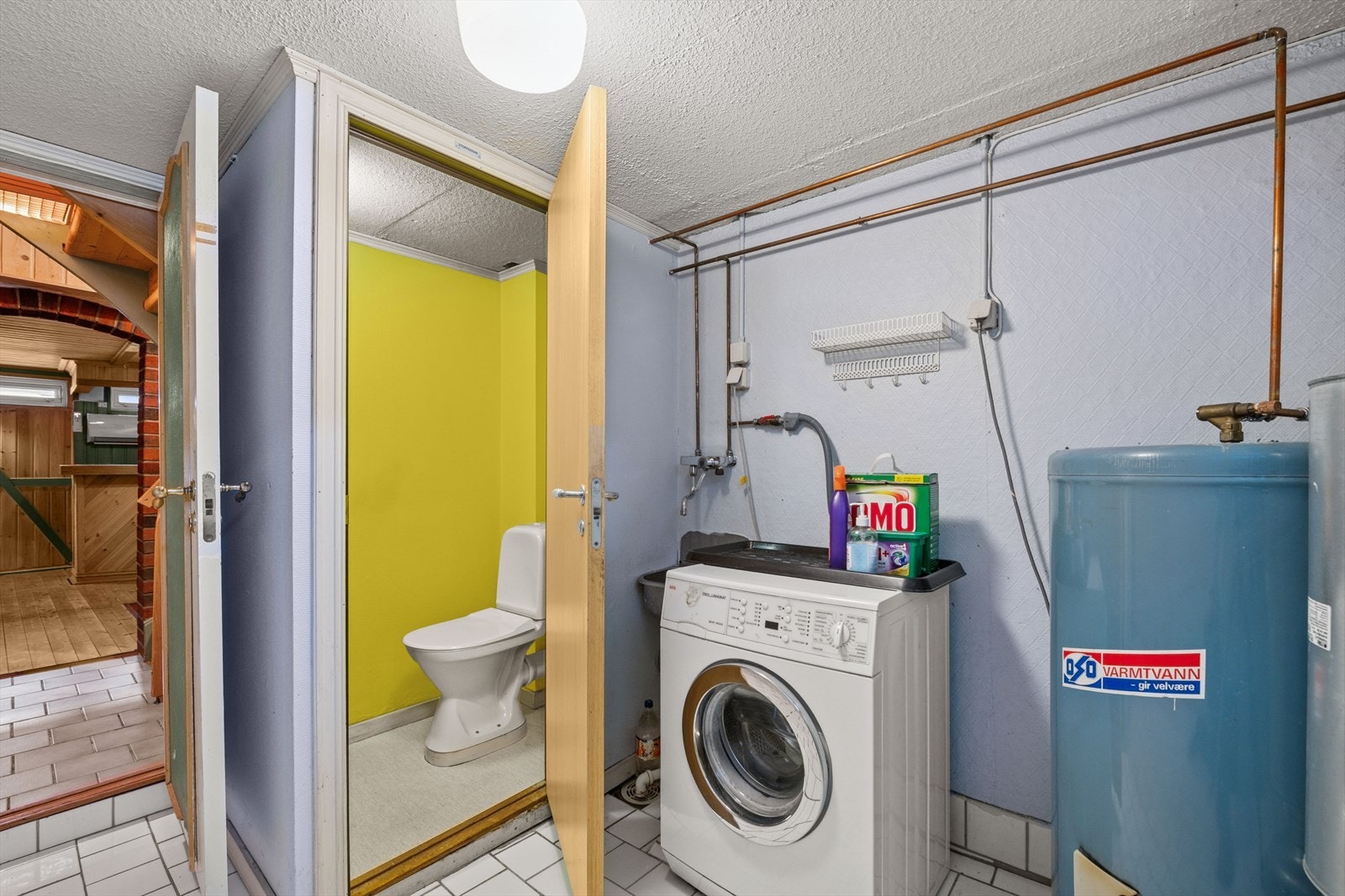 Vaskerom med utslagsvask i stål og opplegg for vaskemaskin. Galleribilde