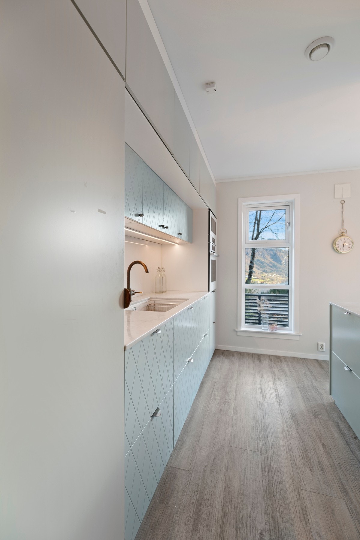 Innredningen har malte fronter og marmor benkeplate
med glassplate mot overskapene. Galleribilde