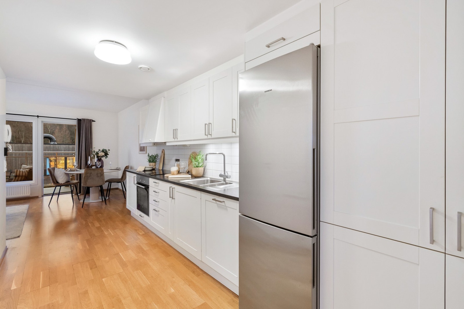 Lyst, moderne kjøkken med god skapplass. Hvit, stilren utførelse. Galleribilde