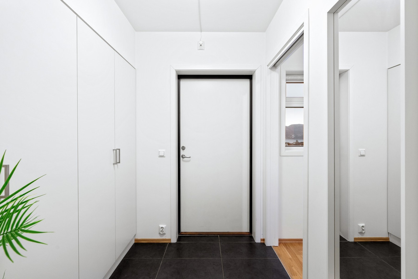 Inngang med fliselagt gulv og mye garderobe plass Galleribilde