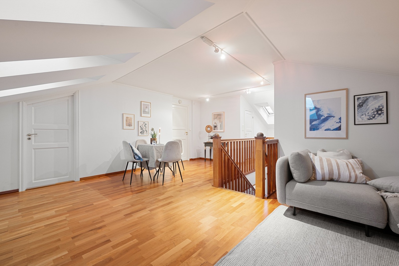 Romslig loftsstue med flere soner for både sofagruppe og spiseplass - et fleksibelt oppholdsrom som kan tilpasses ulike behov. Galleribilde