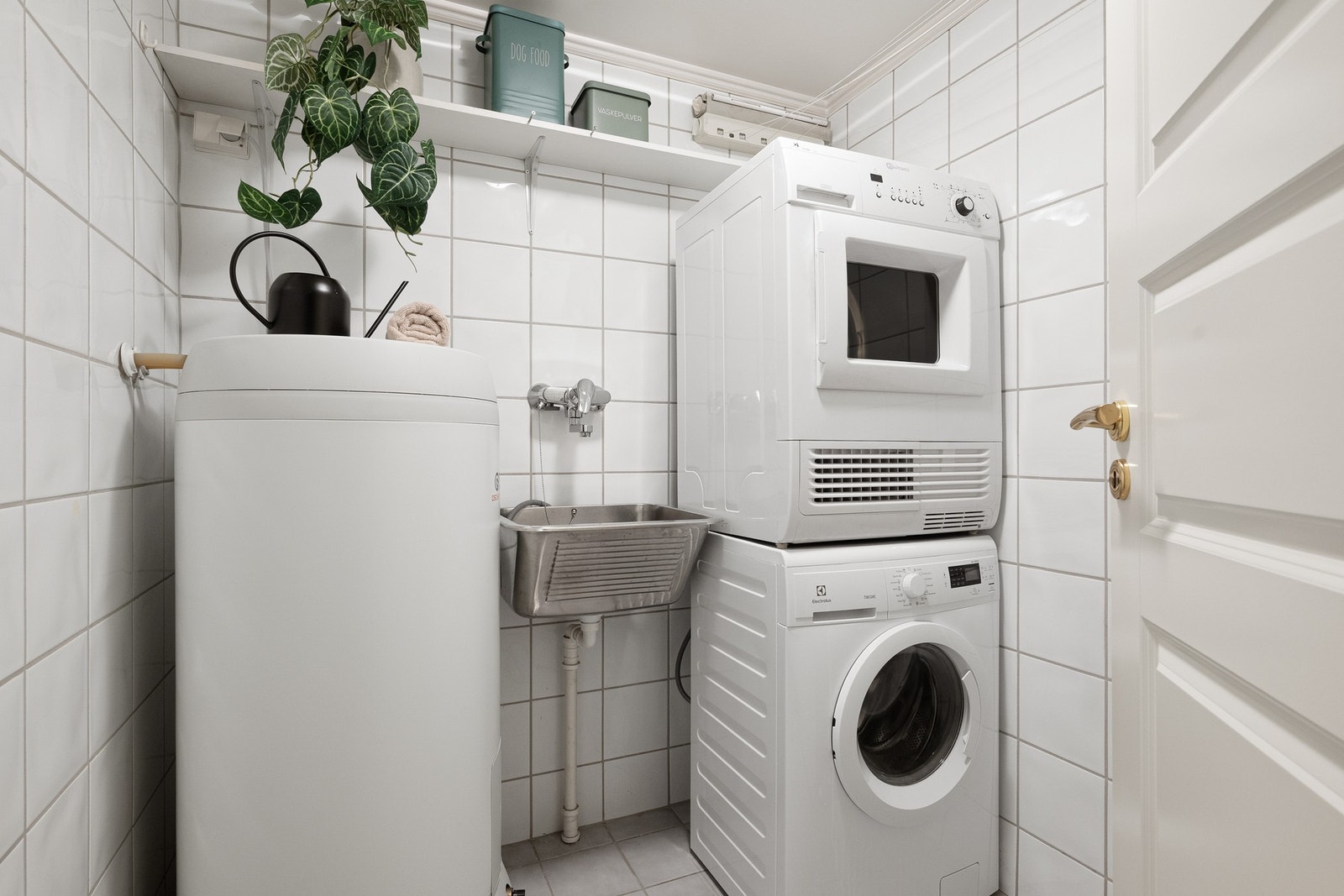 Praktisk vaskerom med utslagsvask, plass for vaskemaskin og tørketrommel i søyle, samt varmtvannsbereder på ca. 194 liter fra 2019. Galleribilde