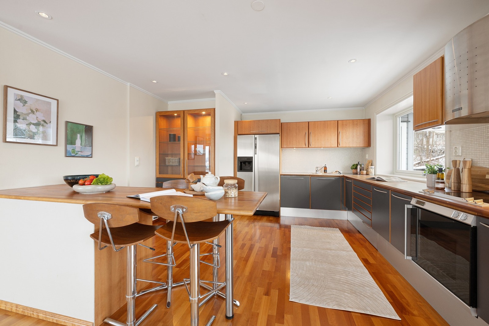 Romslig kjøkken med god benke- og skapplass, praktisk kjøkkenøy og fin overgang mot spiseplassen. Galleribilde