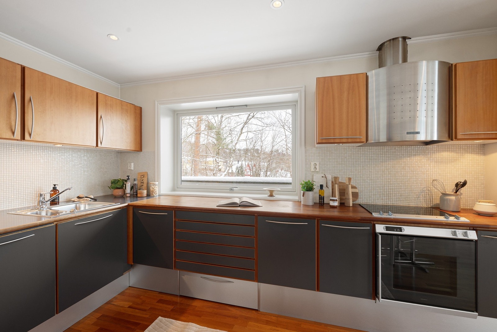 Kjøkken med glatte fronter i heltre og heltre benkeplate - alle hvitevarer medfølger leiligheten. Galleribilde