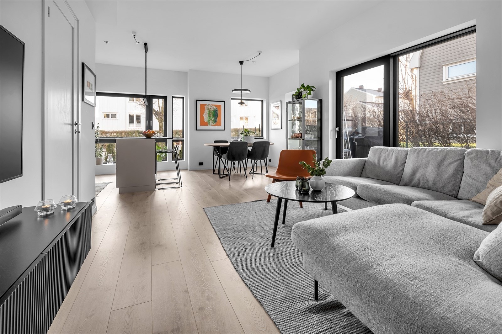 I forlengelsen av gangen kommer vi inn i denne tiltalende og lyse stuen med utgang til egen privat uteplass. Galleribilde