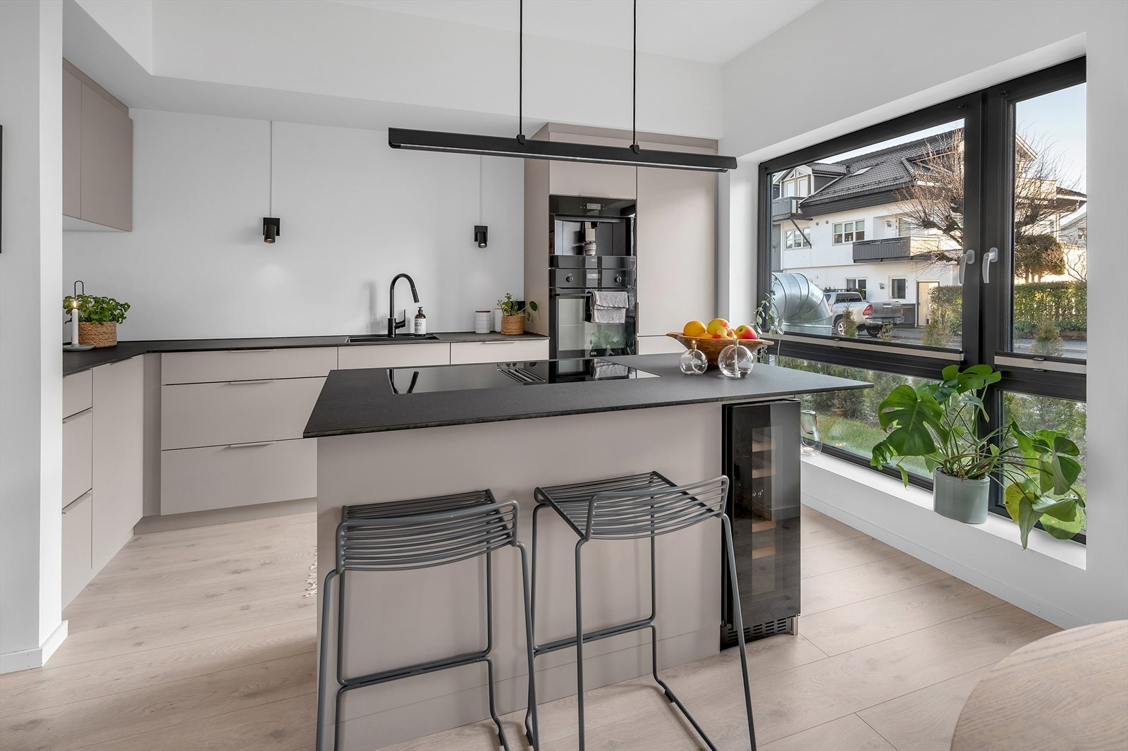 Lekkert kjøkken med påkostede løsninger som vinskap, integrert kaffemaskin, underlimet vask og platetopp. Galleribilde