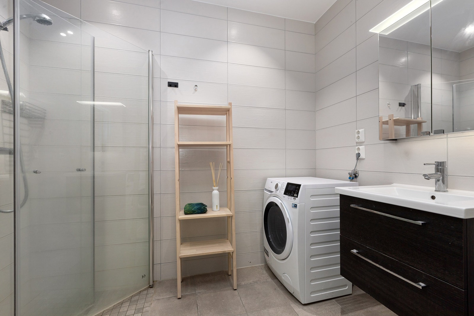 Hovedbad i 2.etg er flislagt med gulvvarme. Innredet med dusjhjørne med innfellbare dører, servantskap med speil og belysning, samt opplegg for vaskemaskin og tørketrommel Galleribilde