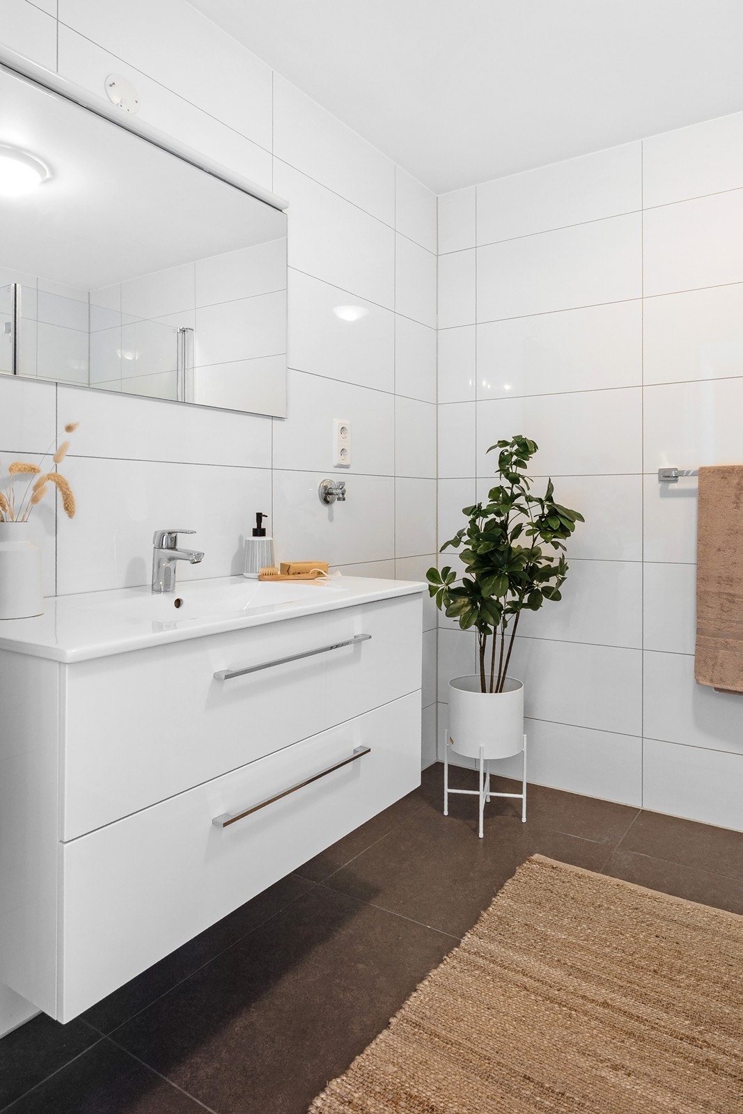 Badet fremstår delikat og tidløst, med flislagte overflater med gulvvarme. Galleribilde