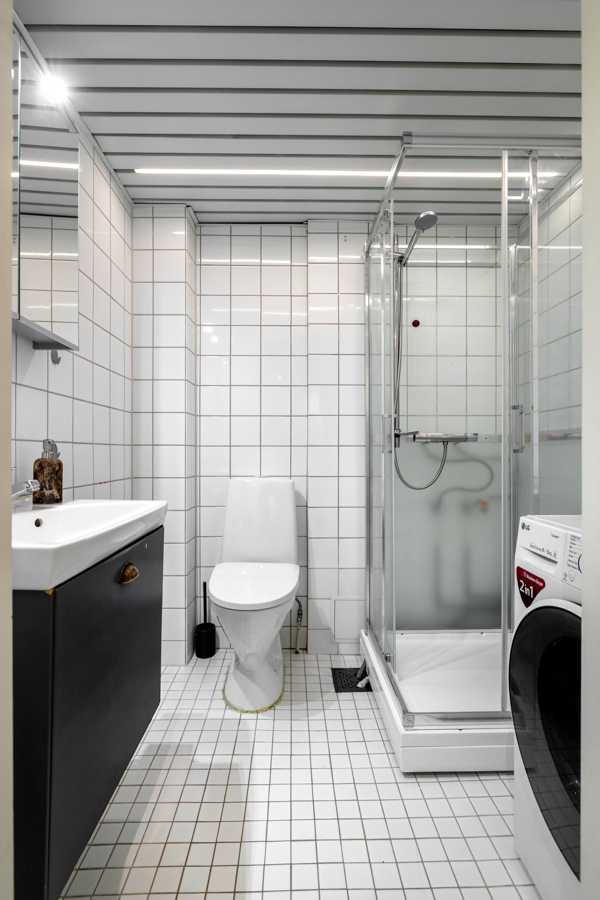 Videre har badet frittstående toalett og dusjhjørne med glassvegger. Det er opplegg for vaskemaskin og varmekabler i gulvet. Galleribilde