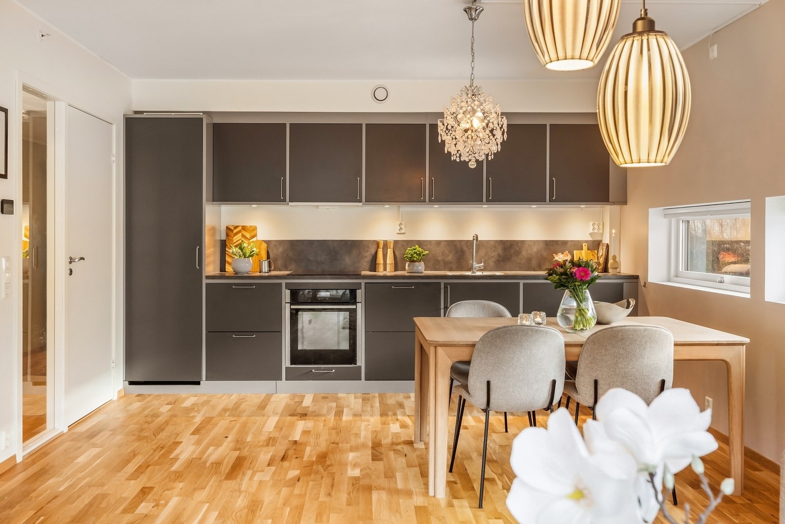 Flott kjøkken med mørke og slette fronter og laminert benkeplate Galleribilde