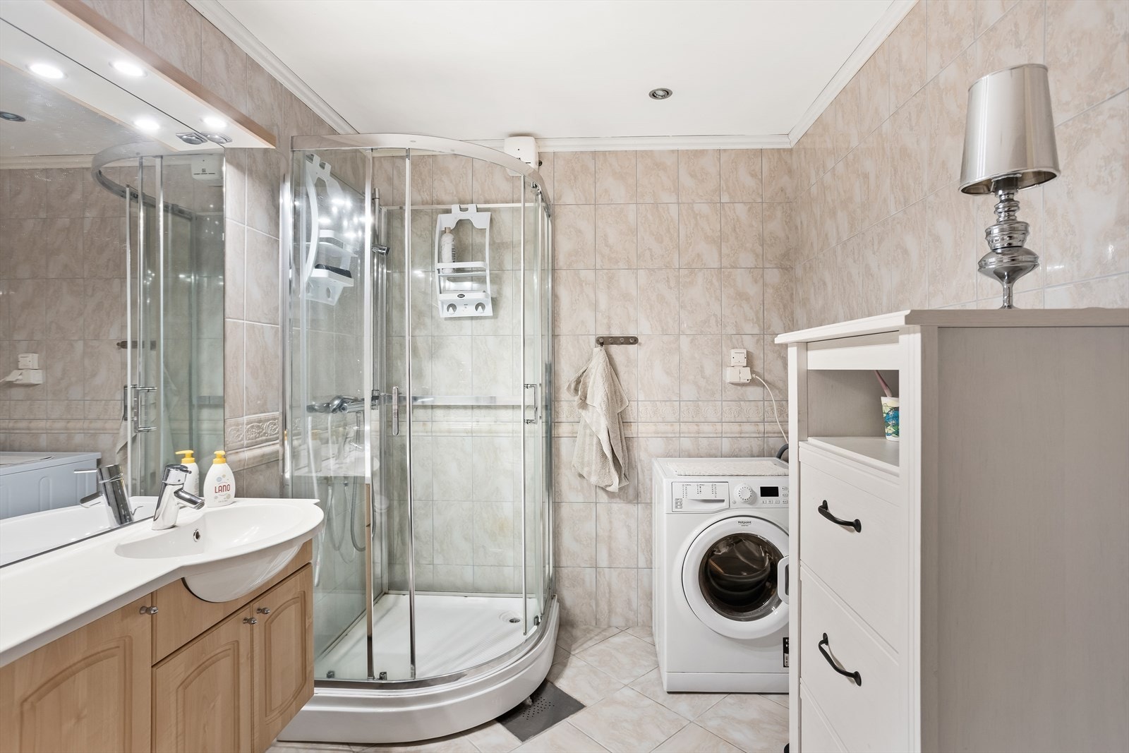 Kombinert bad og vaskerom med dusjkabinett, toalett og opplegg for vaskemaskin. Galleribilde