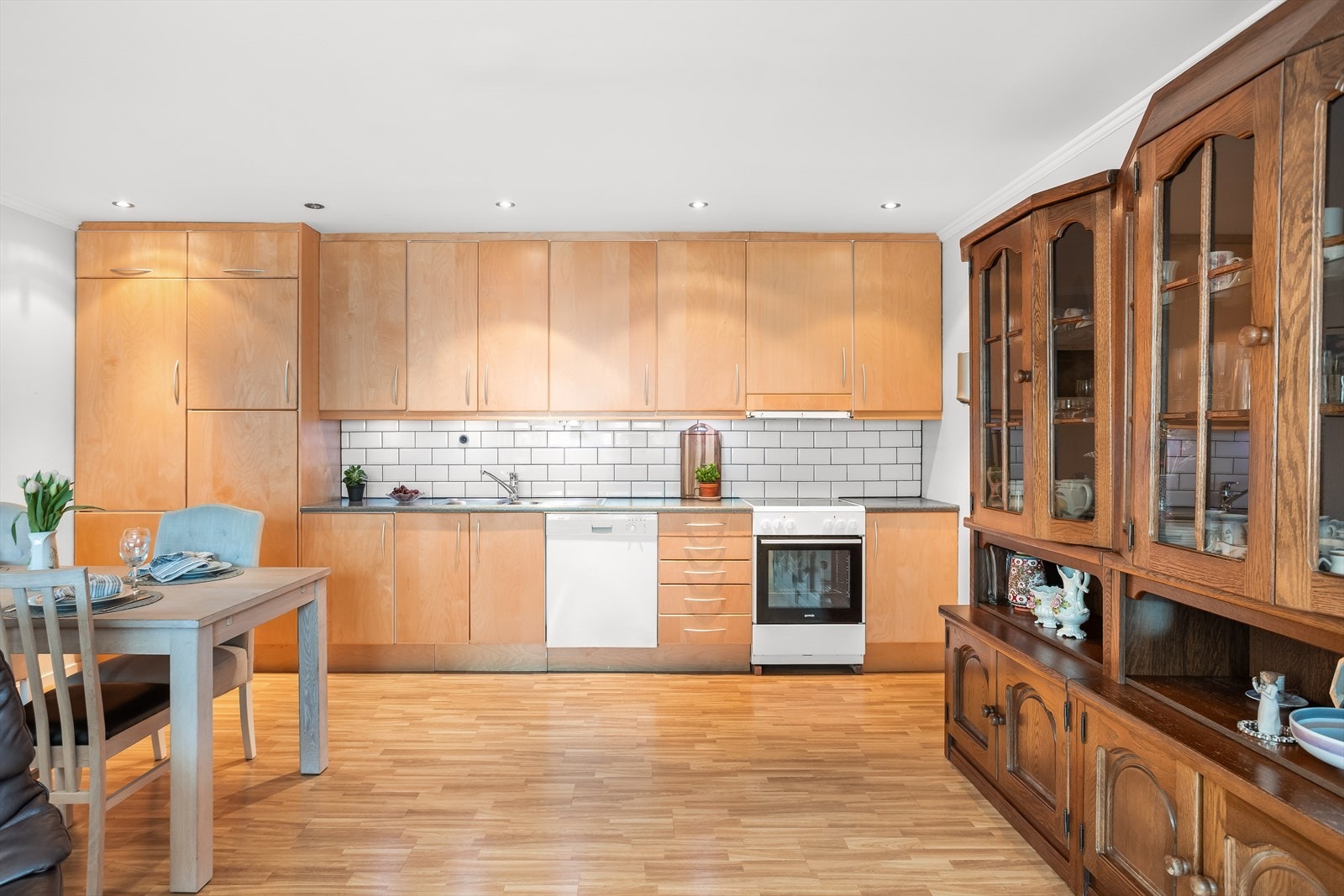 Kjøkkenet har fliser over benken og opplegg for frittstående komfyr og oppvaskmaskin. Galleribilde