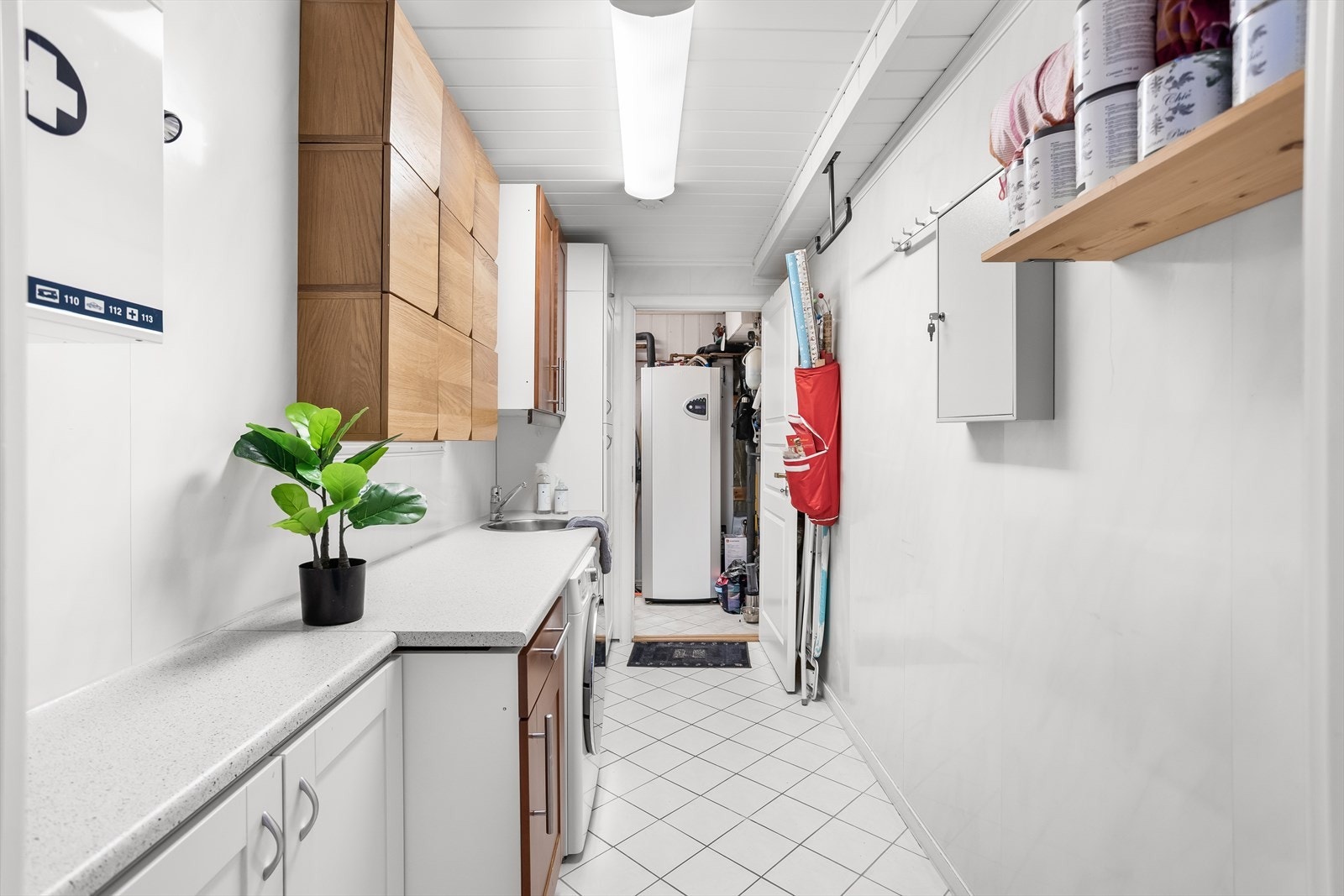 Separat vaskerom i første etasje med flislagt gulv, våtromsplater på veggene og opplegg for vaskemaskin. Galleribilde