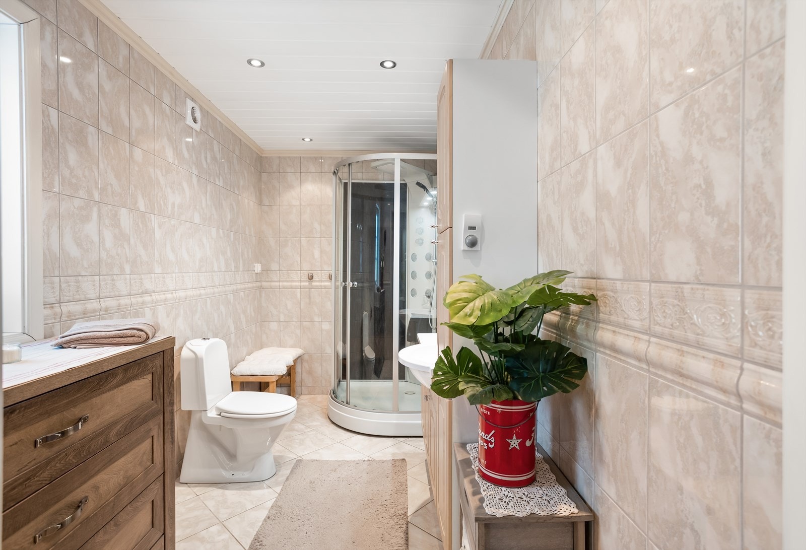 Bad i første etasje med fliser på gulv og vegger, utstyrt med dusjkabinett. Galleribilde