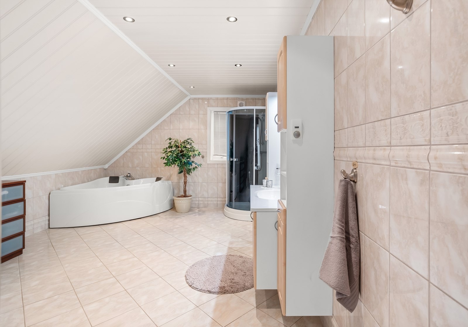 Stort og tiltalende bad i loftsetasjen med flislagte overflater og vannbåren gulvvarme. Galleribilde