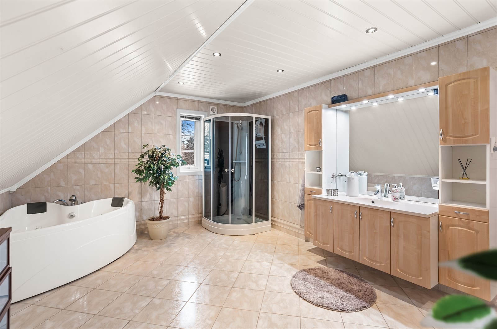 Badet er innredet med både dusjkabinett og et hjørnebadekar med boblefunksjon. Galleribilde