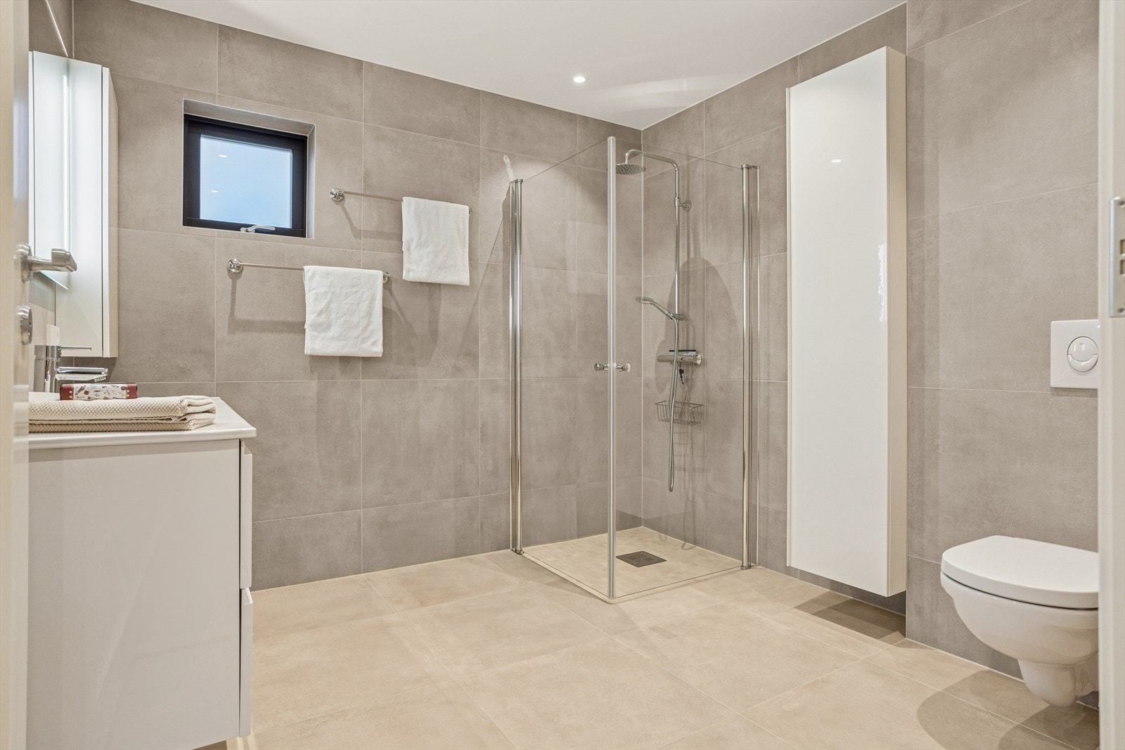 Pent flislagt bad i 2. etg. med dusj, servant med innredning og vegghengt toalett. Galleribilde