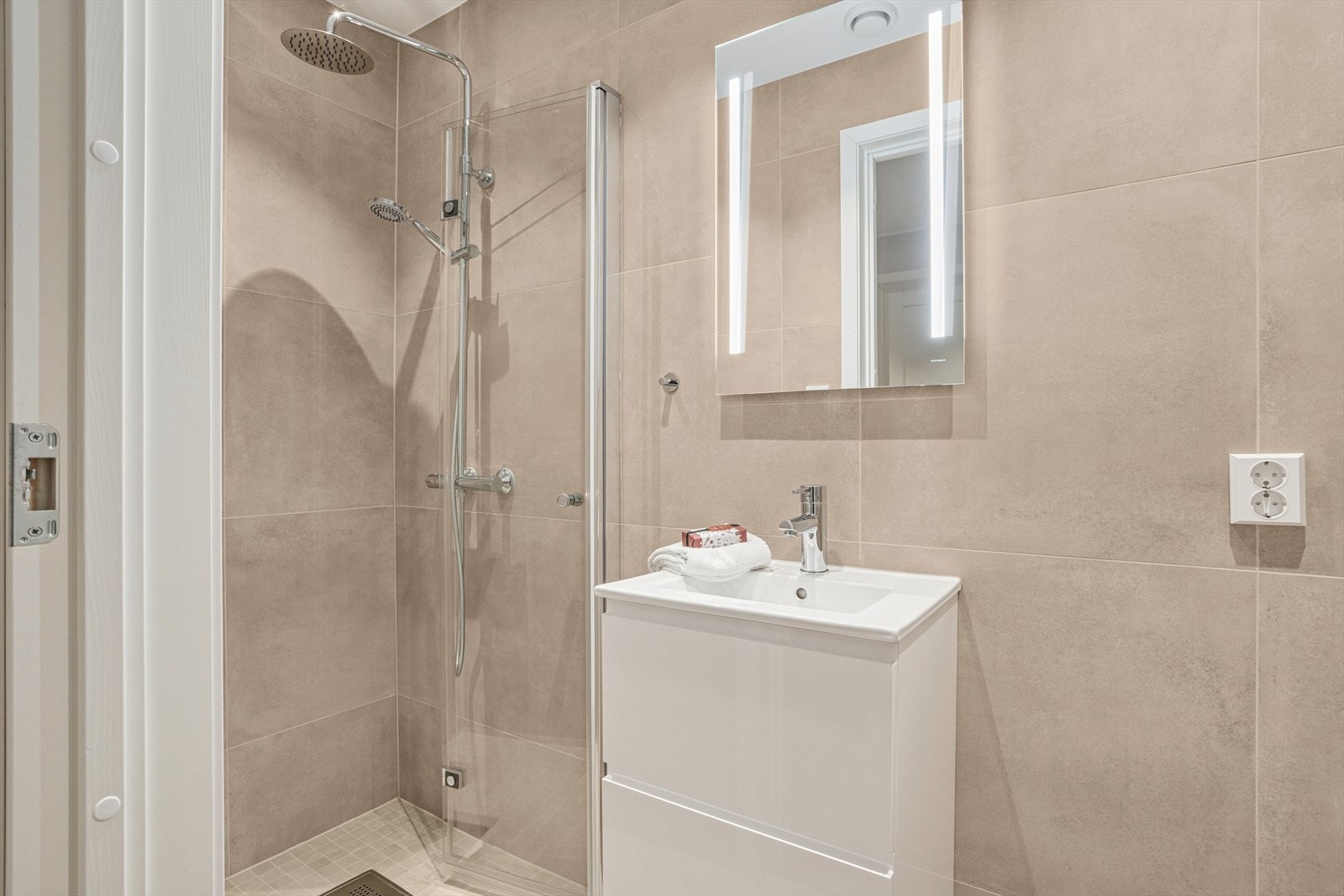 Flislagt bad i 1. etg. med dusj, servant med innredning og vegghengt toalett. Varmekabler i gulv Galleribilde