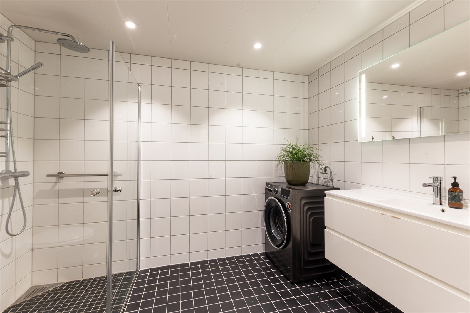 Stort bad, der bla. gulvet er flislagt med sklisikre fliser. Romslig innredning med stort LED belyst speil. Downlights i himling. Galleribilde