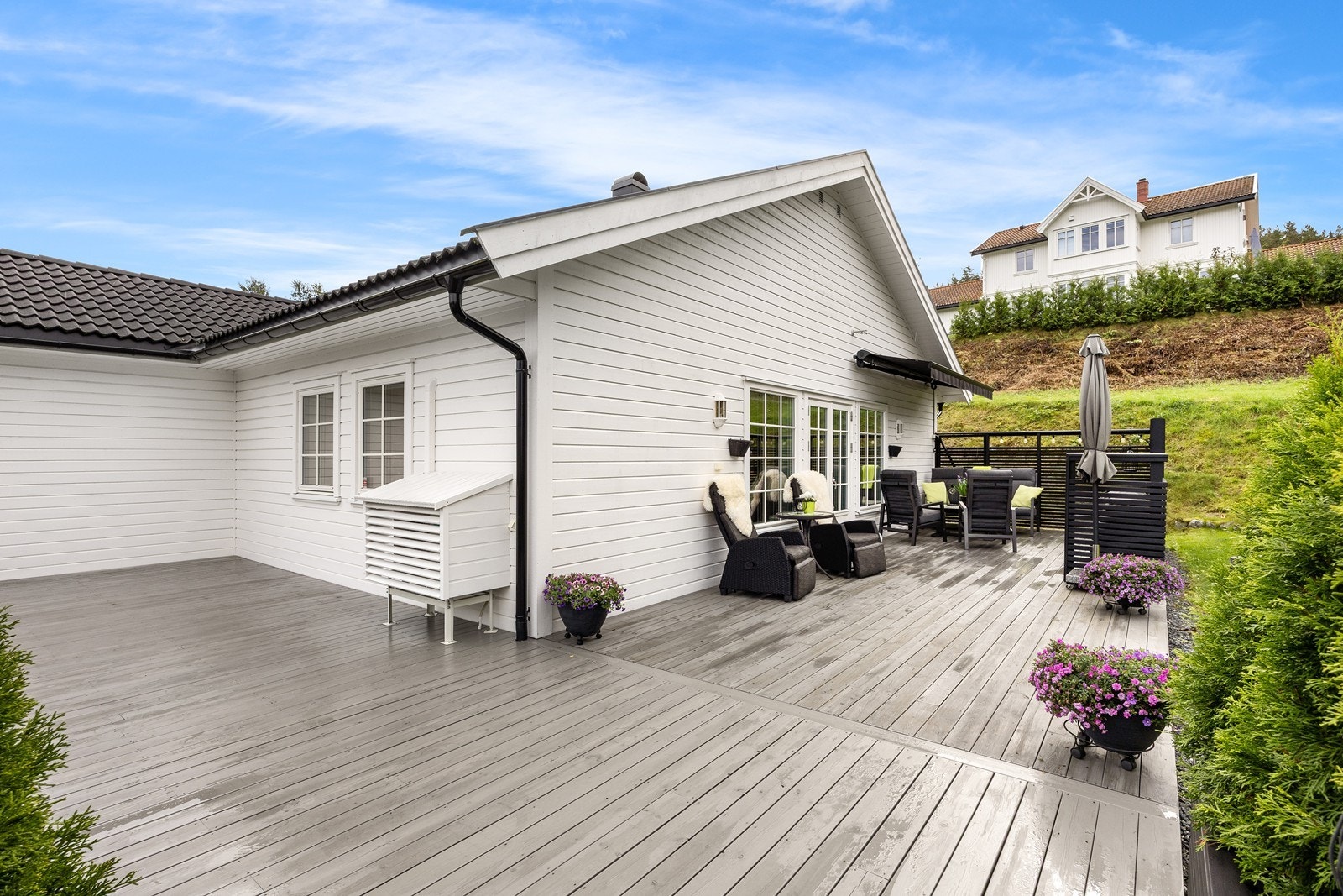 Fra stuen er det utgang til en stor, vinklet markterrasse i tre. Galleribilde