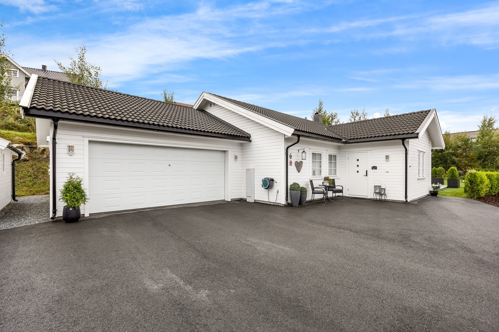 Eiendommen har en stor, asfaltert gårdsplass og et singlet areal rundt uteboden. Ved inngangspartiet er det plass til et hyggelig kafesett. Galleribilde