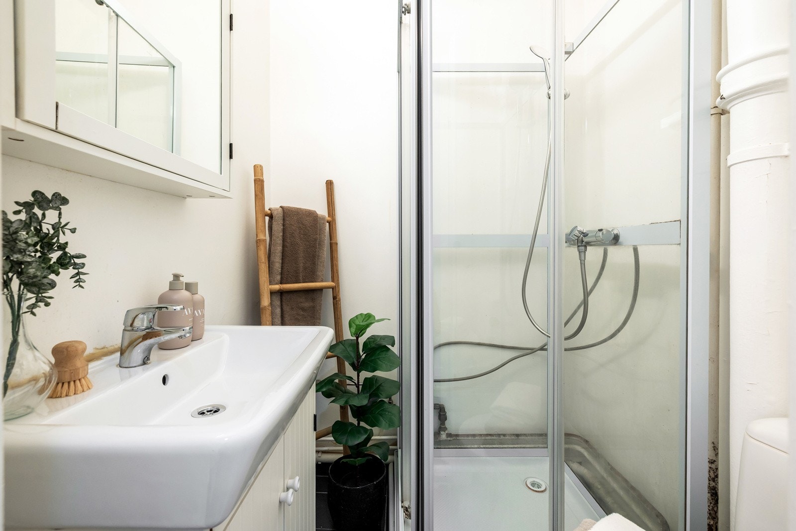 Badet er innredet med servant, speilskap, toalett og dusjkabinett Galleribilde