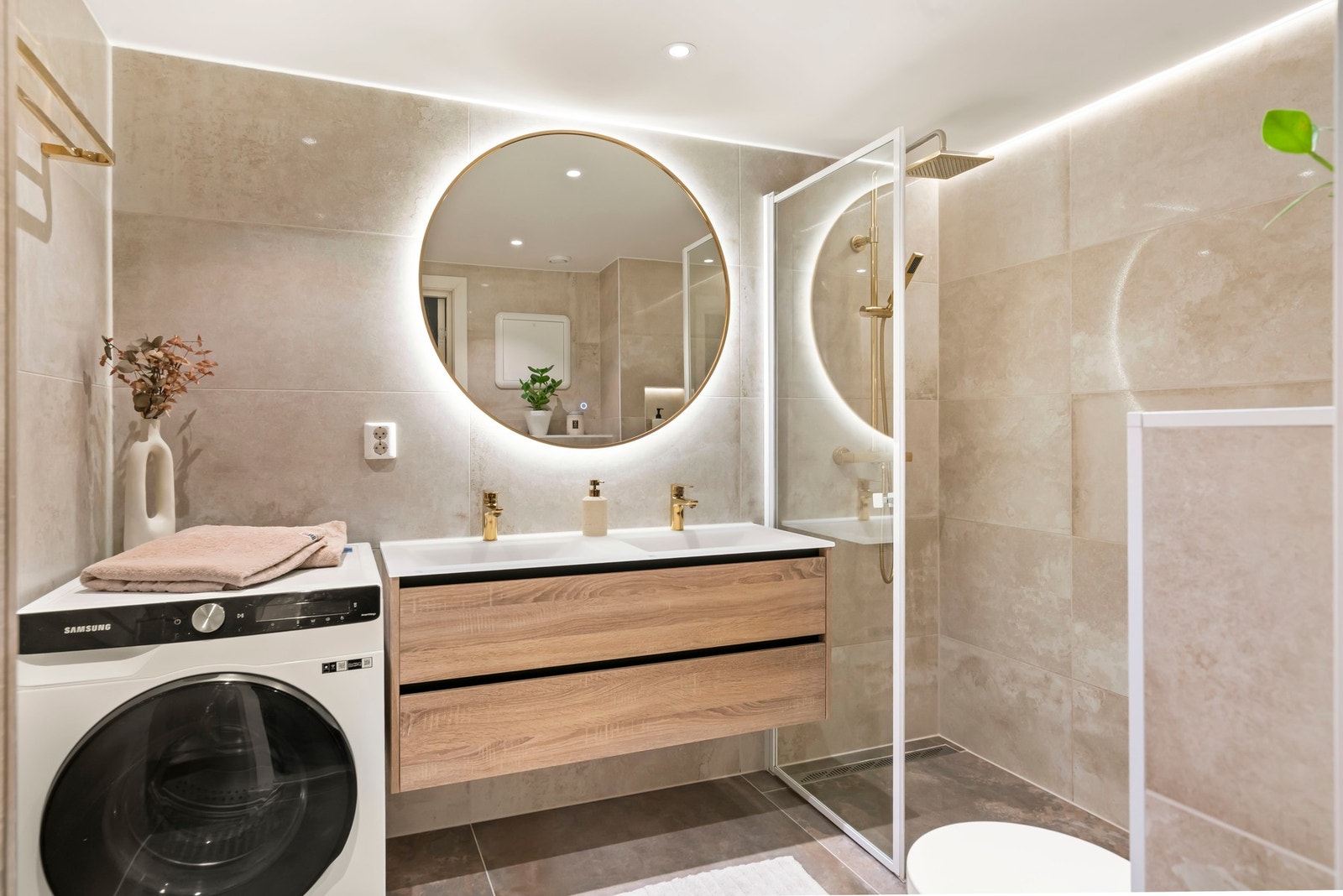 Badet har videre vegghengt toalett, opplegg for vaskemaskin og spotter i tak Galleribilde